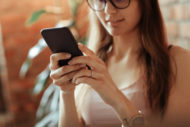 Hermosa joven con smartphone en casa