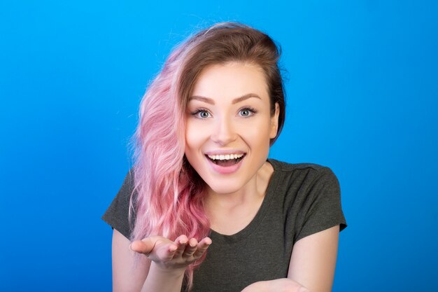 Hermosa joven sonriendo y mostrando la palma de su mano