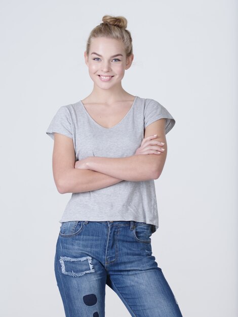 Hermosa joven sonriente mujer caucásica posando sobre fondo blanco.