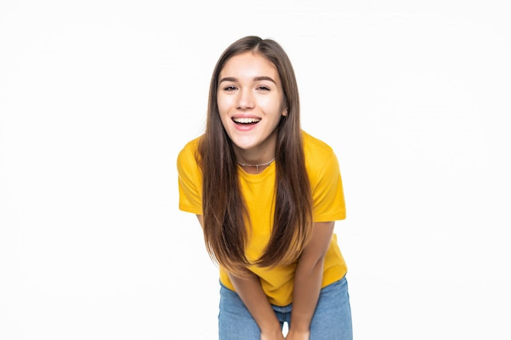 Foto gratuito hermosa joven sonriente pleasend aislado en la pared blanca