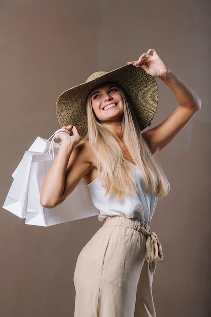 Foto gratuita hermosa joven sosteniendo bolsas de compras