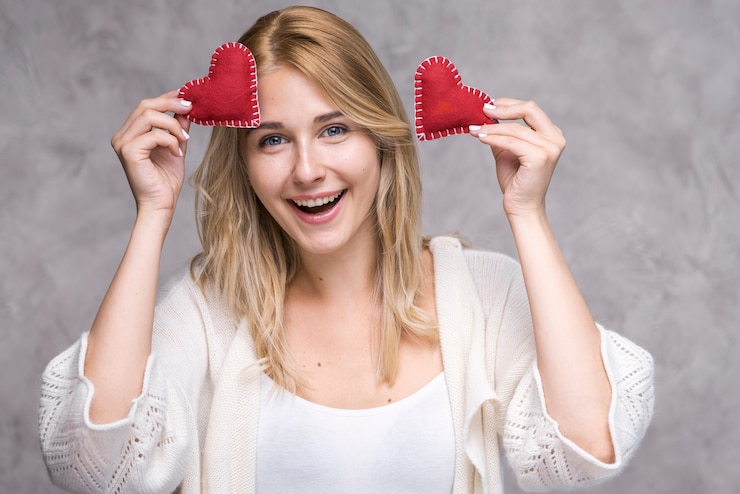 Foto gratuito hermosa joven sosteniendo corazones de amor