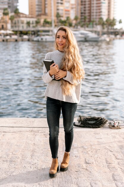 Hermosa joven sosteniendo un libro al aire libre