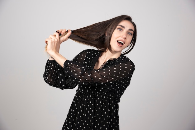 Una hermosa joven sosteniendo su cabello sano y brillante.