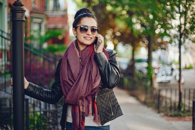 hermosa joven en su casa y usa un teléfono