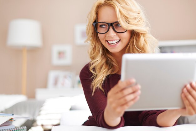 Hermosa joven con tableta digital en casa