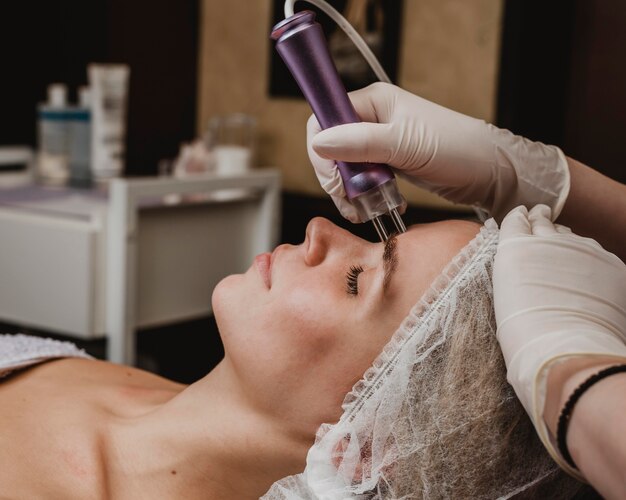 Hermosa joven con un tratamiento cosmético en el centro de bienestar