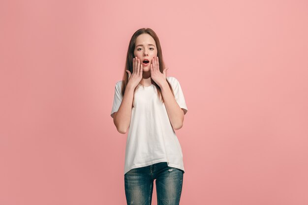 Hermosa jovencita mirando sorprendido aislado en rosa