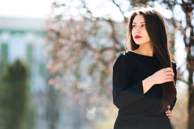 Hermosa jovencita posando en una chaqueta de cuero negro en el parque