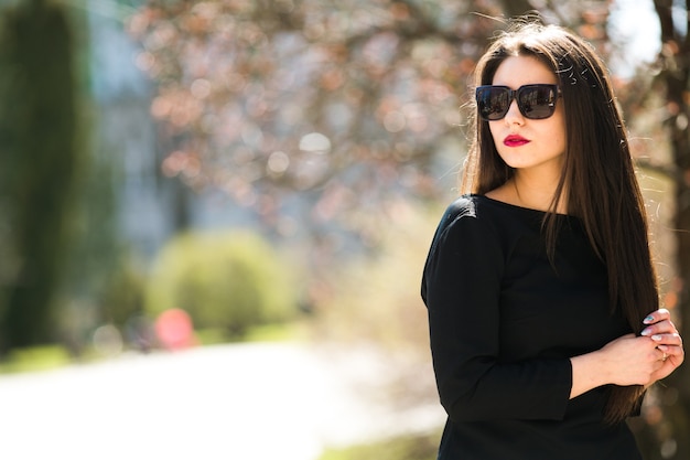 Hermosa jovencita posando en una chaqueta de cuero negro en el parque