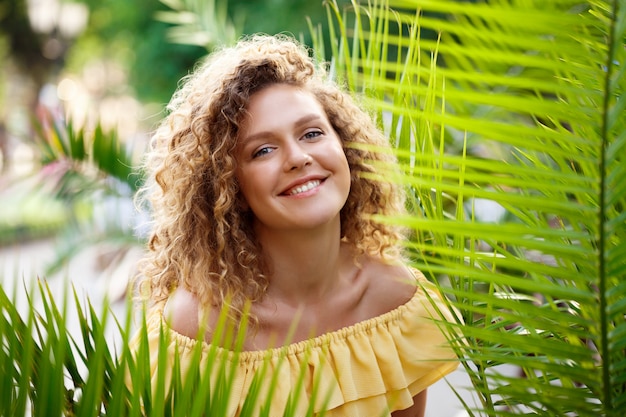 Foto gratuita hermosa jovencita en vestido amarillo posando en el parque de la ciudad.