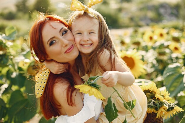 Hermosa y linda familia en un campo con girasoles