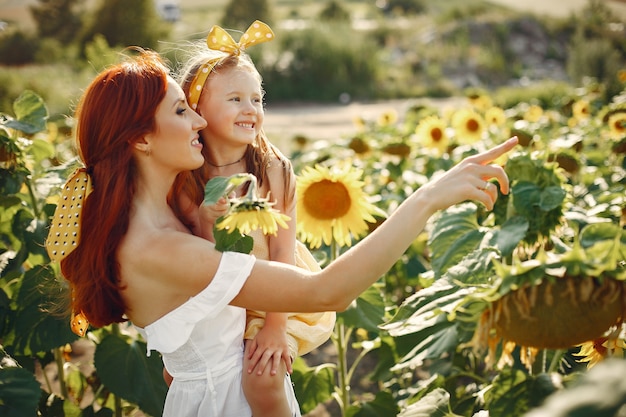 Hermosa y linda familia en un campo con girasoles