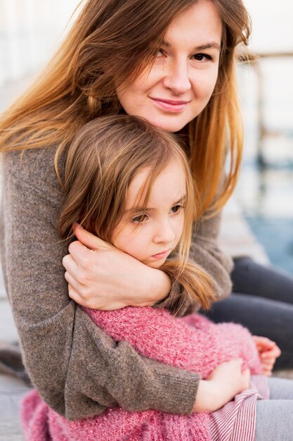 Hermosa madre abrazando a hija de cerca