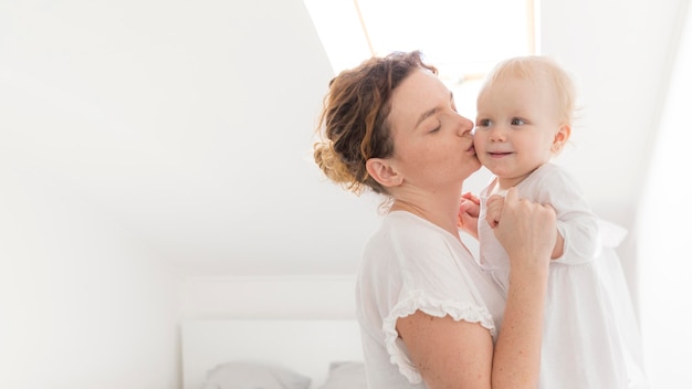 Hermosa madre besando a niña