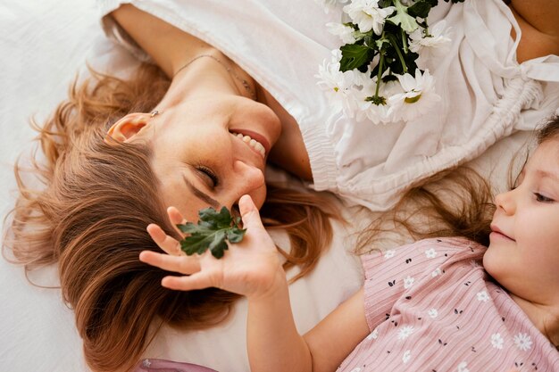 Hermosa madre e hija con ramo de delicadas flores de primavera