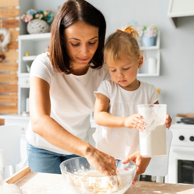 Hermosa madre y encantadora hija cocinando juntas