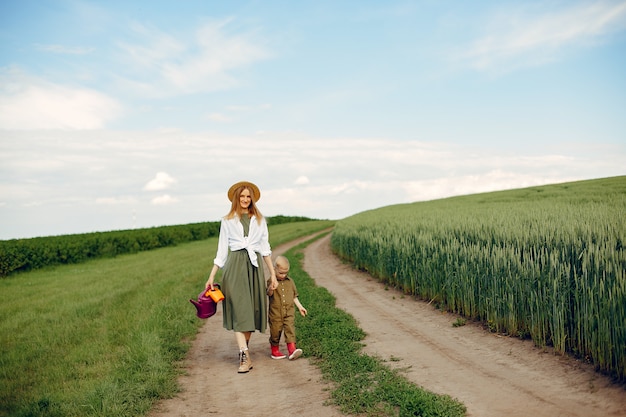 Hermosa madre con hijo pequeño en un campo de verano