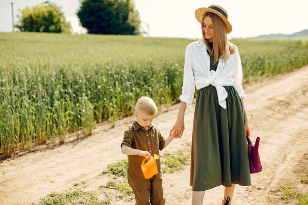 Hermosa madre con hijo pequeño en un campo de verano