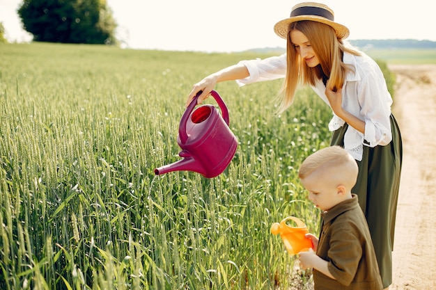 Hermosa madre con hijo pequeño en un campo de verano