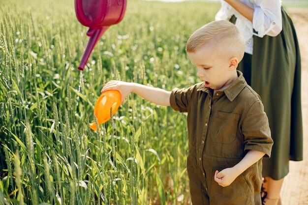 Hermosa madre con hijo pequeño en un campo de verano