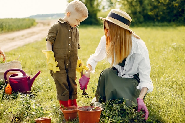 Hermosa madre con hijo pequeño en un campo de verano