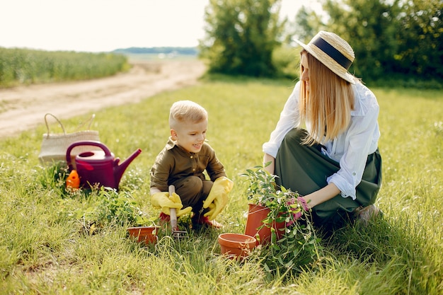 Hermosa madre con hijo pequeño en un campo de verano