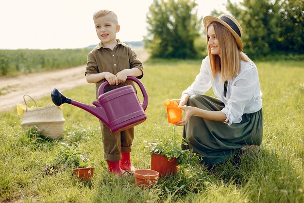 Hermosa madre con hijo pequeño en un campo de verano