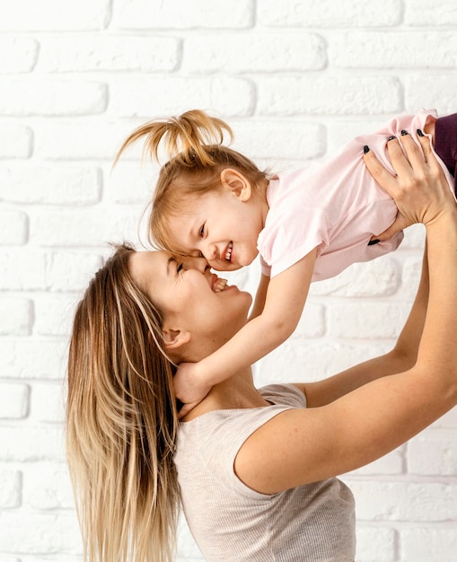 Hermosa madre jugando con su hija en casa