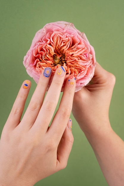 Foto gratuita hermosa manicura y flor de cerca