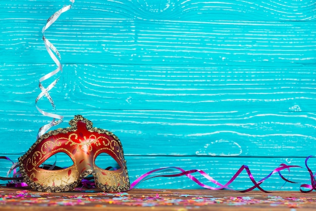 Foto gratuita hermosa máscara de carnaval en el fondo de madera azul