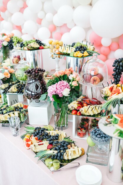 Hermosa mesa con dulces y frutas para invitados.