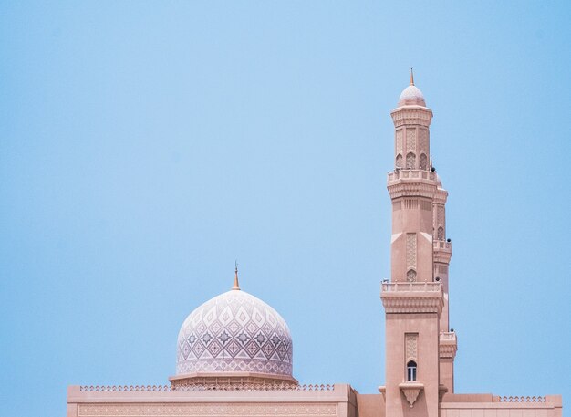 Hermosa mezquita blanca bajo un cielo azul en Khasab, Omán