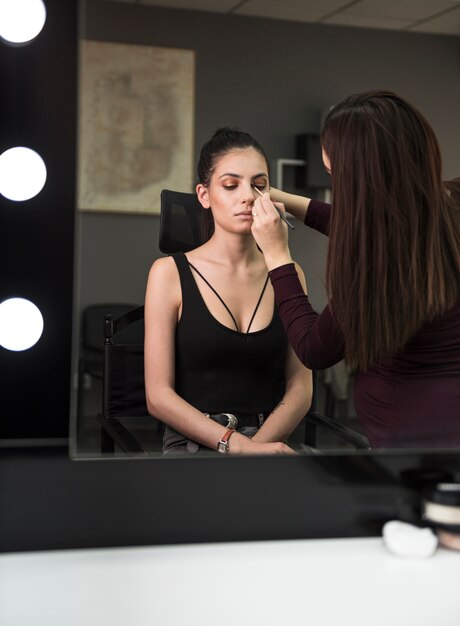 Hermosa modelo en estudio de maquillaje