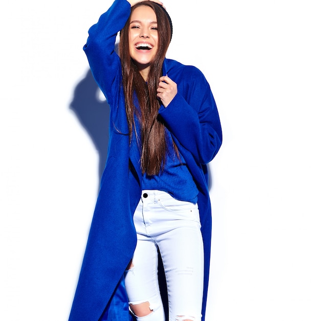 Foto gratuita hermosa modelo de mujer morena hipster sonriente en elegante abrigo azul aislado en blanco