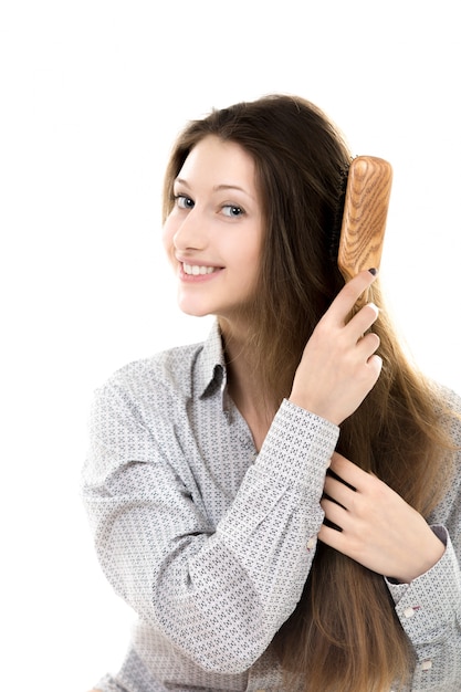 Hermosa modelo peinándose el pelo con sonrisa