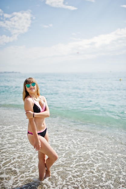 Hermosa modelo relajándose en una playa vestida con un traje de baño