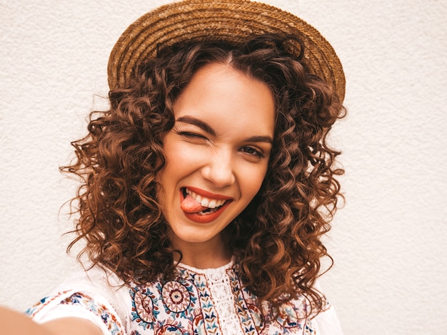 Foto gratuita hermosa modelo sonriente con peinado afro rizos vestido con vestido blanco hipster de verano.