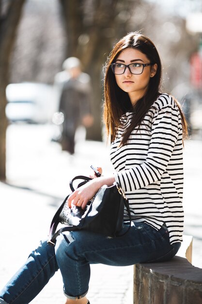 Hermosa modelo con un suéter de rayas y está hablando por teléfono.