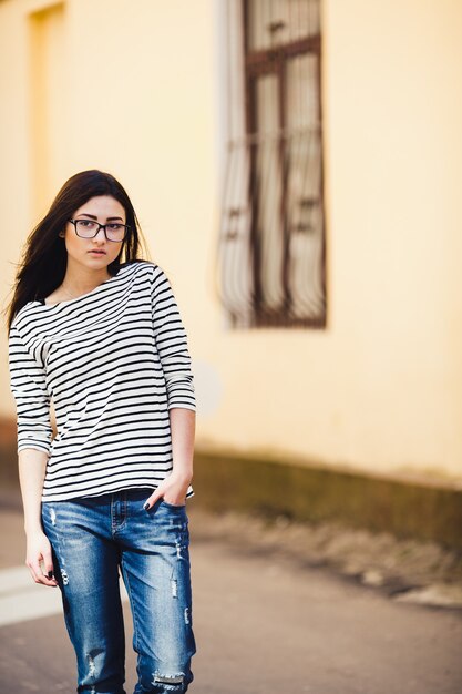 Hermosa modelo con un suéter a rayas en gafas