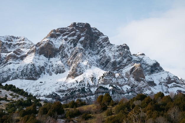 Foto gratuita hermosa montaña rocosa cubierta de nieve bajo un cielo nublado