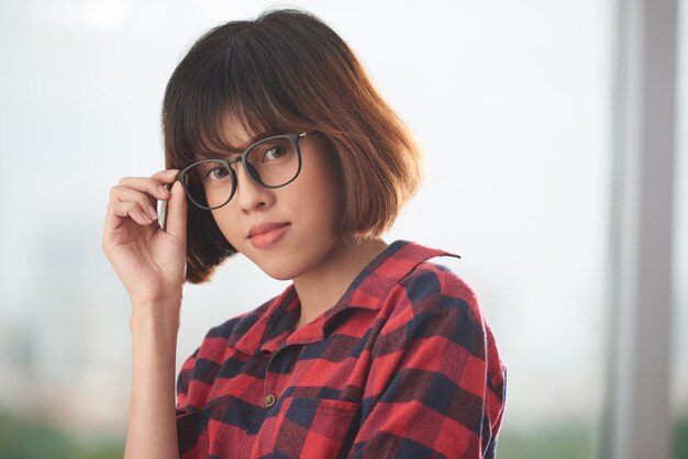 Hermosa morena con gafas mirando a la cámara