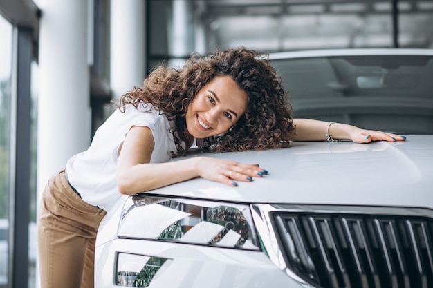 Hermosa mujer abrazando un auto