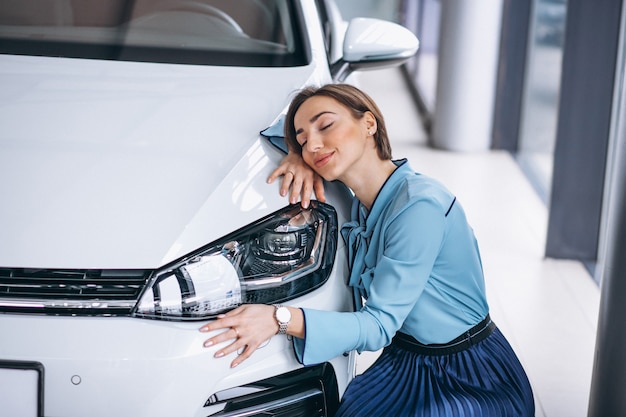 Foto gratuita hermosa mujer abrazando un coche