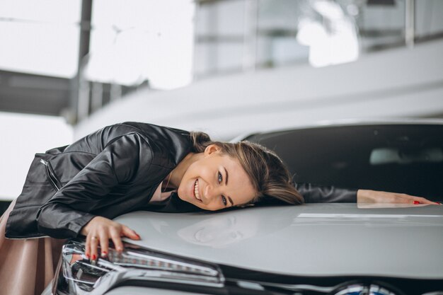 Hermosa mujer abrazando un coche