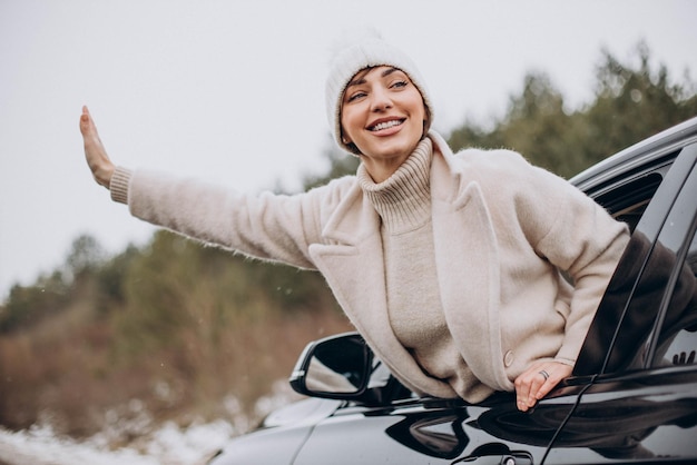 Hermosa mujer en abrigo de invierno sentado en el coche