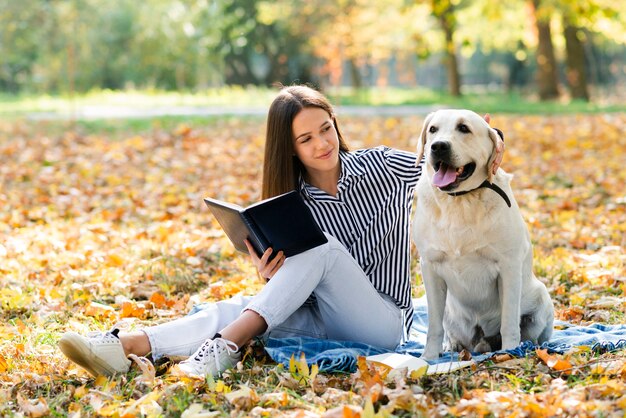 Hermosa mujer acariciando a su perro