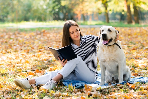 Hermosa mujer acariciando a su perro