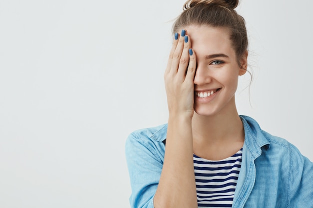 Hermosa mujer adolescente cubriendo un ojo con la mano