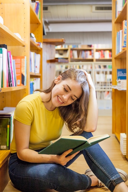 Hermosa mujer adolescente leyendo en el piso